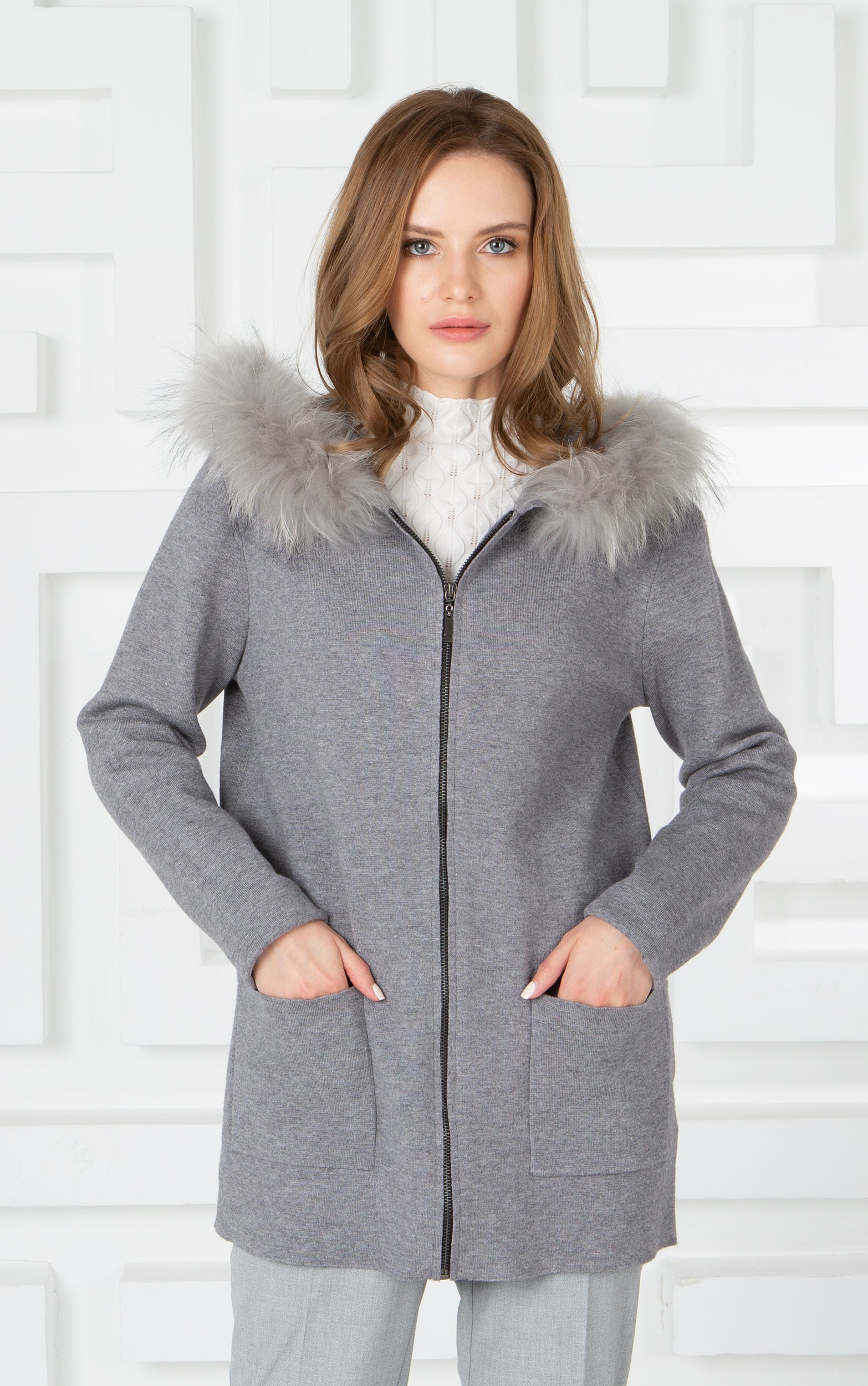 Lange Strickjacke mit Reißverschluss, Vordertaschen und Kapuze mit Pelzbesatz