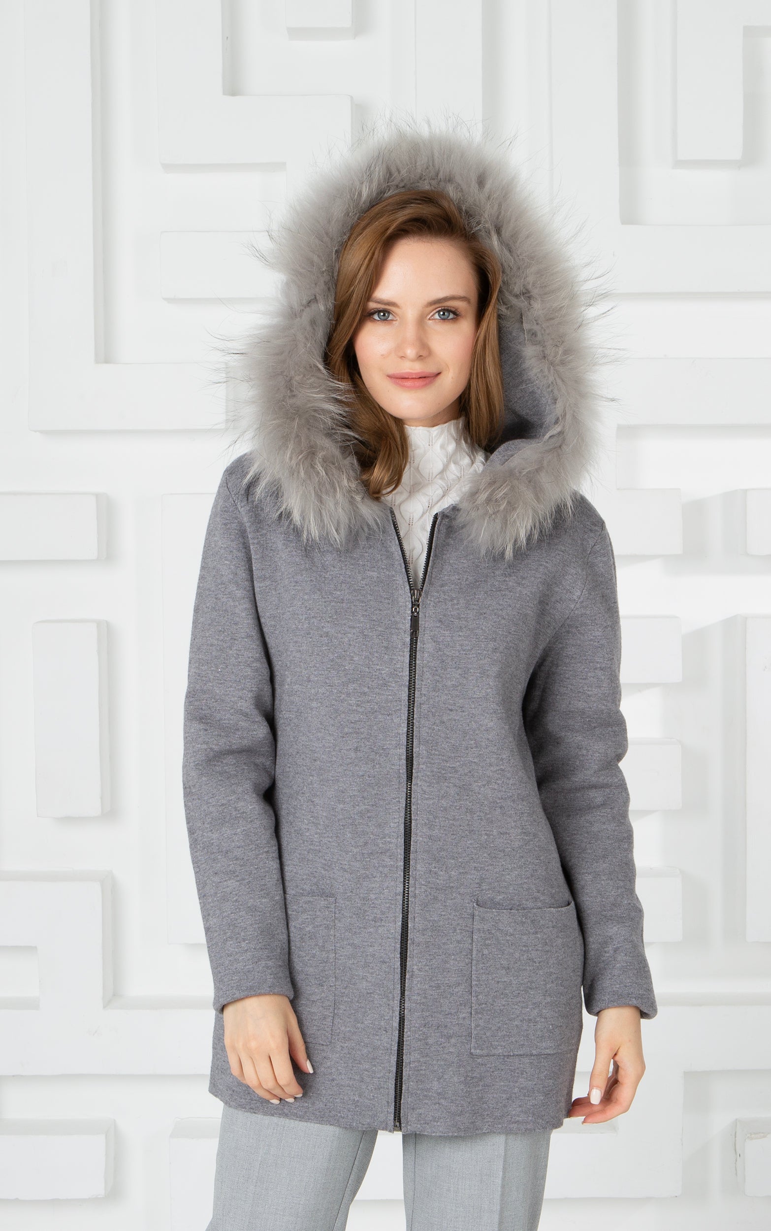 Lange Strickjacke mit Reißverschluss, Vordertaschen und Kapuze mit Pelzbesatz